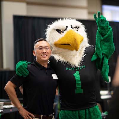 New UNT faculty member posing with Scrappy