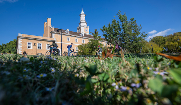 Students riding bikes past Hurley Admin Building