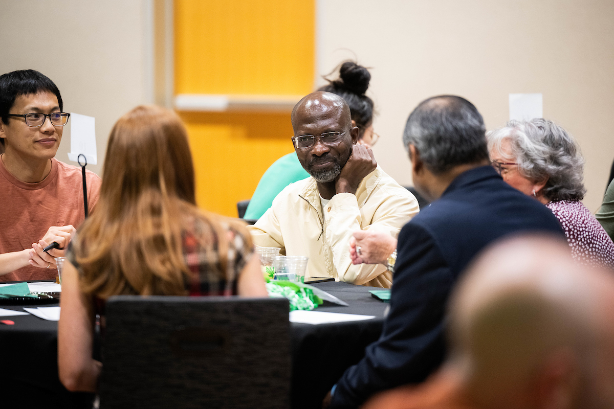 faculty having a conversation at a table