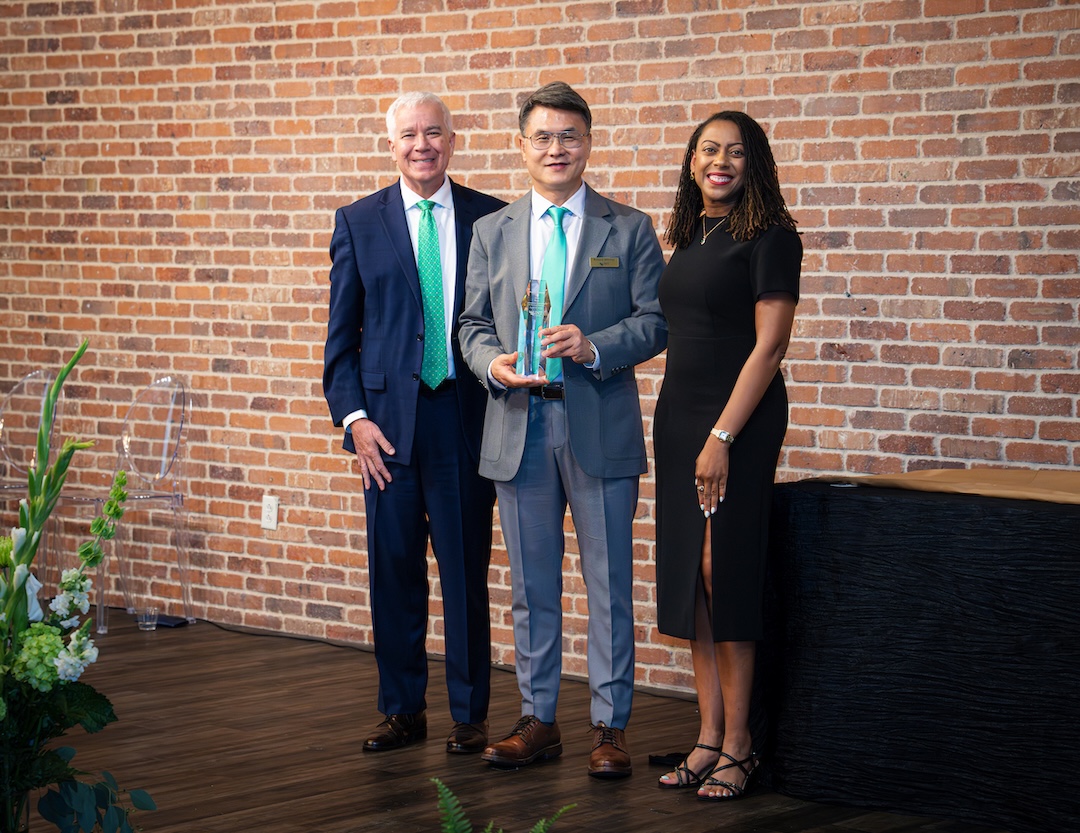 Dan Kim receiving award on stage
