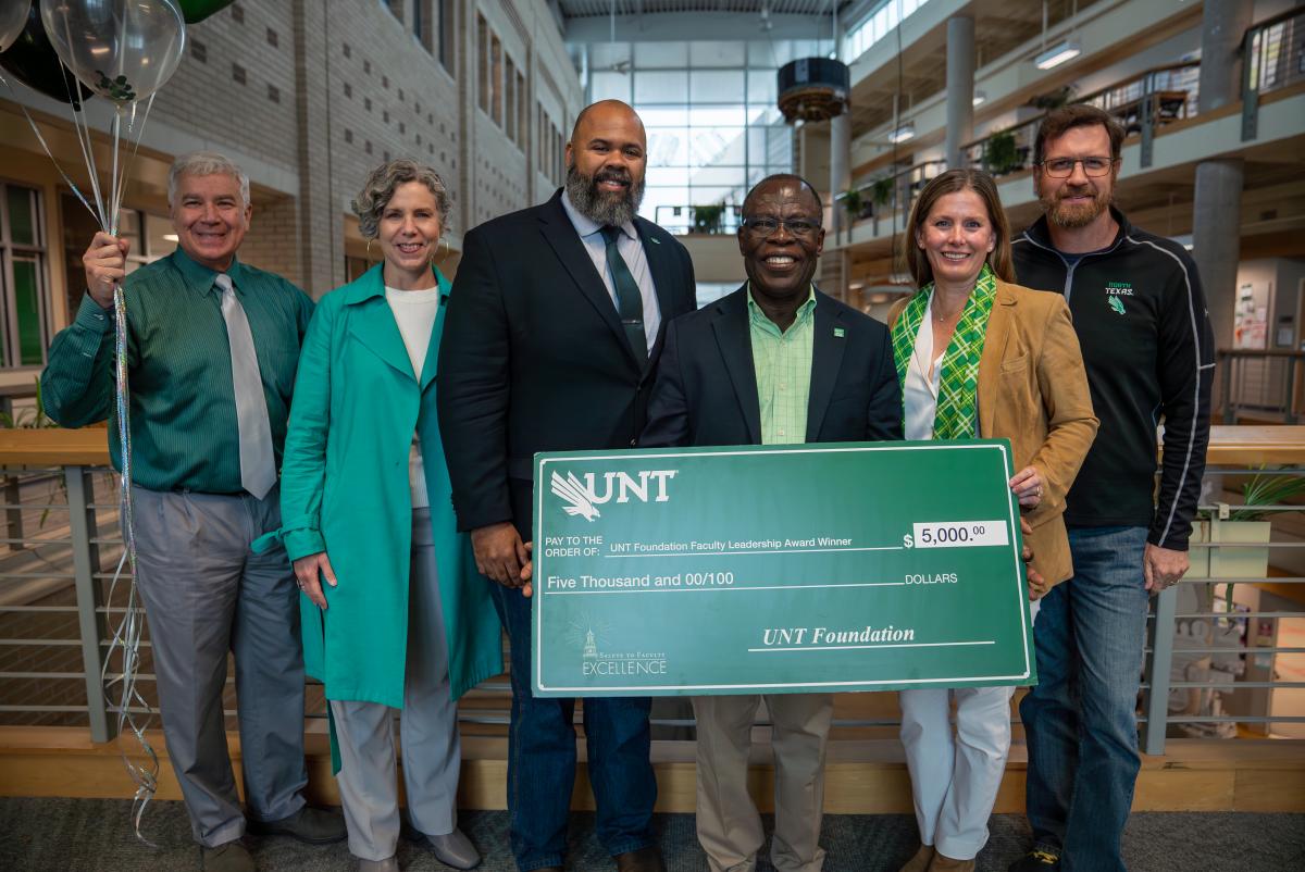 Joseph Oppong holding giant award check with UNT administrators and Foundation CEO