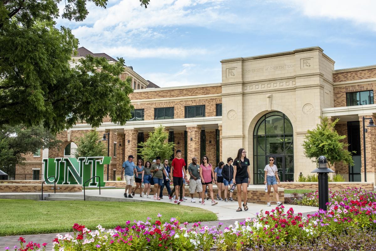 Students walking in front of the UNT Welcome Center.