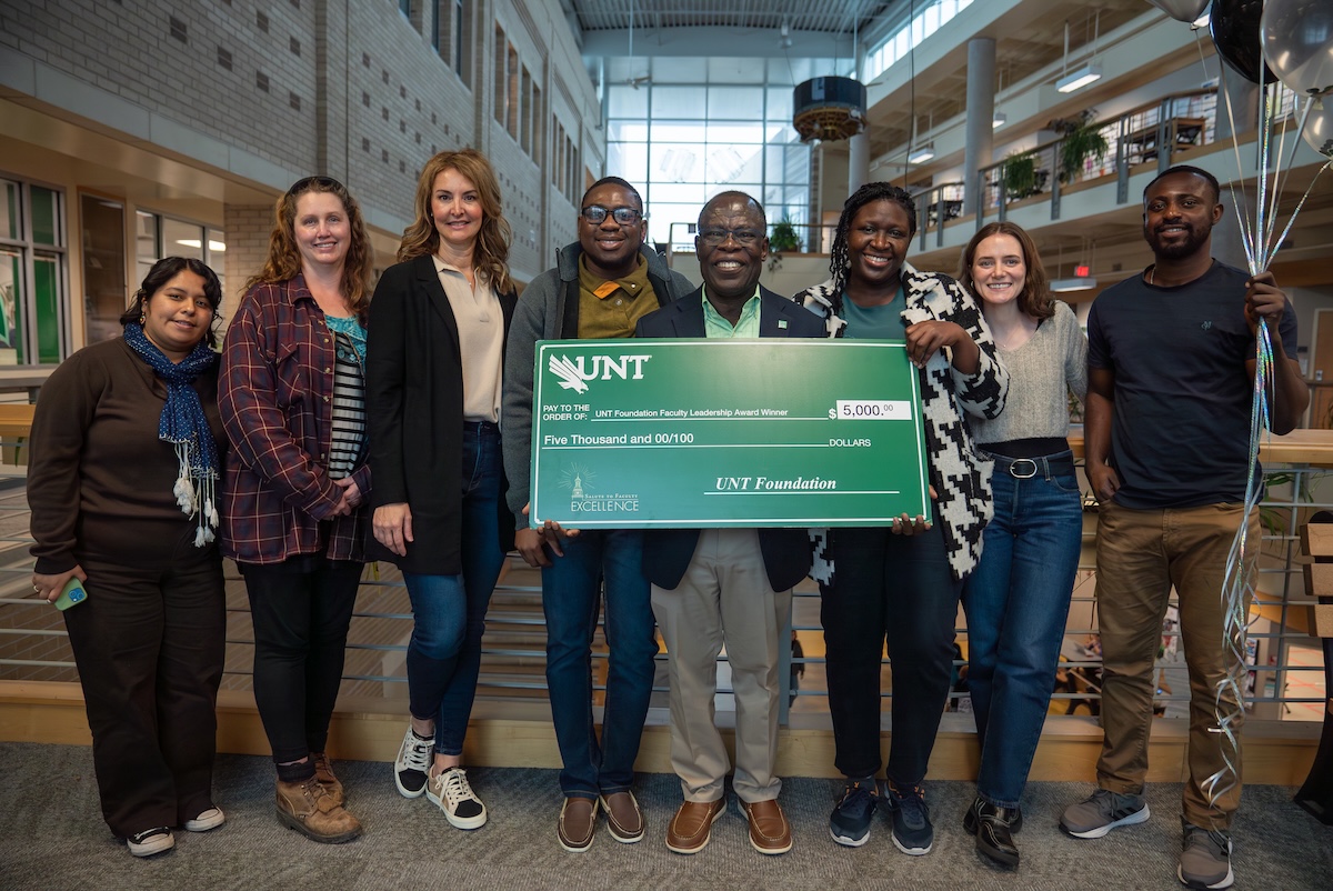 Joseph Oppong poses with students holding Foundation Award check