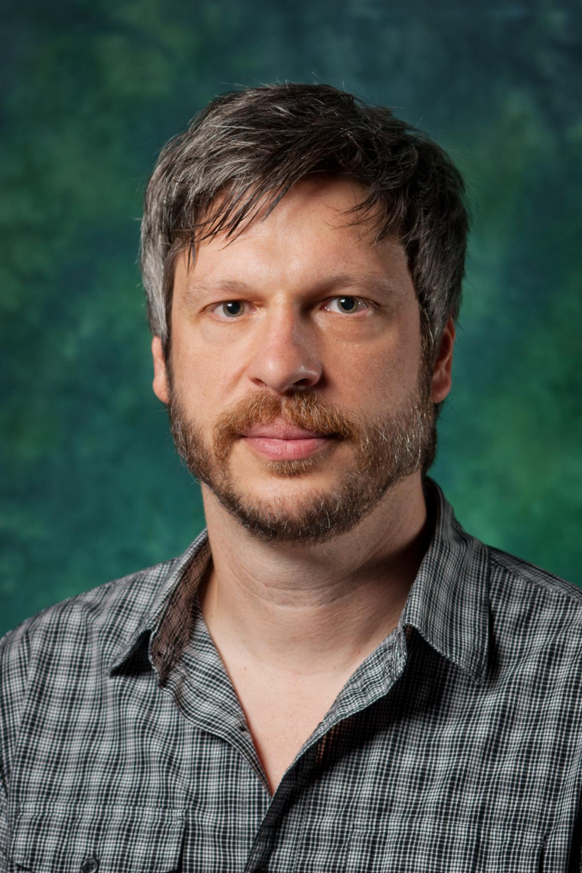 Corey Marks in front of a green background