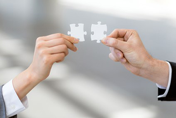 Two hands holding puzzle pieces 