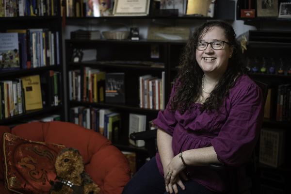UNT assistant professor Sarah Evans sits in front of a bookcase