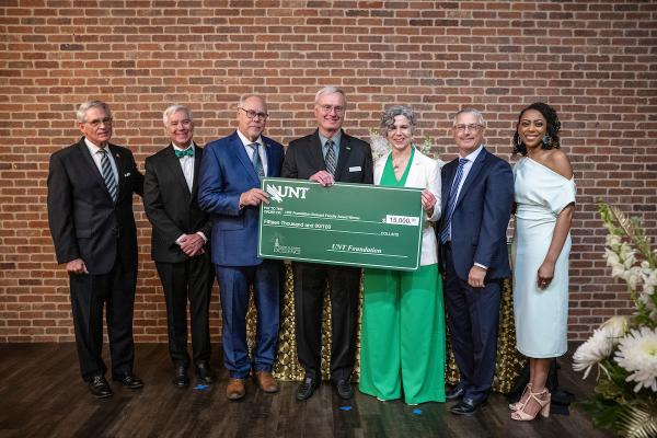 Professor Robert Bland accepting the UNT Foundation Eminent Faculty Award giant check