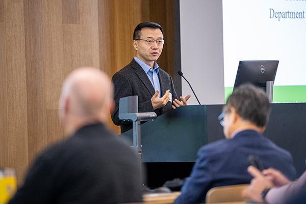 UNT professor Song Fu speaking at podium at AI Symposium 